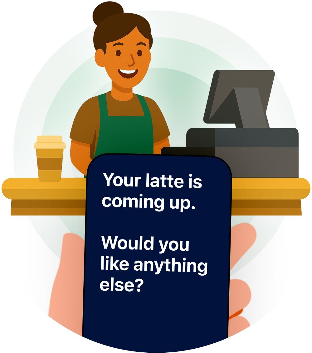 A barista at a counter with a phone showing live captions